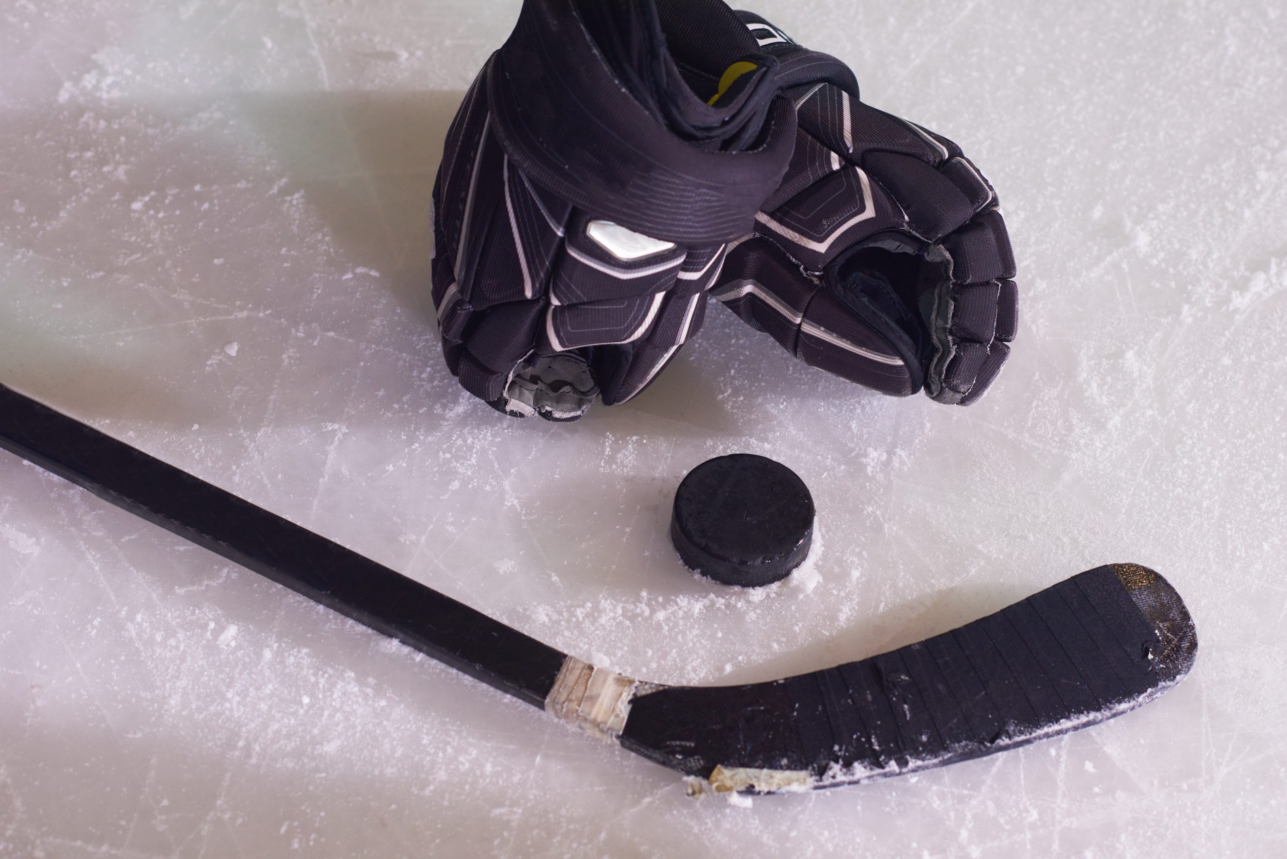 two hockey sticsk and puck on ice, start of the game, competition concept in business, top view